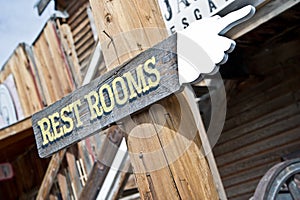 A rustic sign pointing the way to restrooms