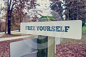 Rustic signboard outdoors in an autumn park with words Free your