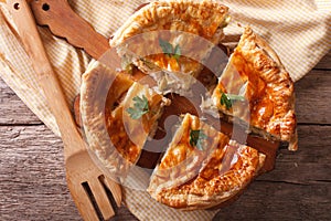 Rustic sliced chicken pie close-up on the table. horizontal top
