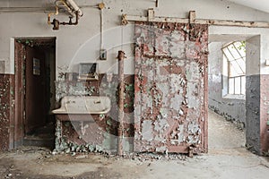 Rustic sliding barn door with decaying sink in an abandoned factory