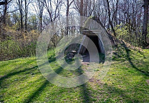 Rustic solitary hut made of wooden timbers and green sod exterior.