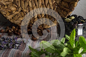 Rustic still life, basket, nuts, lavender and mulberry on the table.