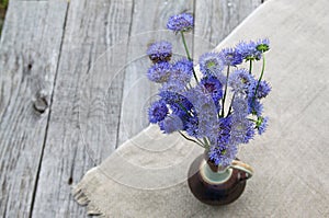 Rustic still life with a bouquet of blue flowers on a wooden background photo