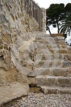 Rustic stone staircase next to a stone wall