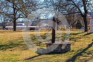 Rustic stone water well in a tranquil countryside setting