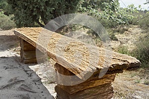 Rustic strongly structured old bench as solid wood as a resting place for hikers in the heath, Germany