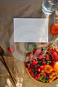 Rustic summer seasonal stationery card mock up with hard shadows, sunlight and fresh fruits and berries. Top view