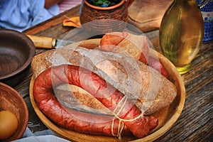 Rustic table with homemade sausage and bread. The food in vintage style, wooden table on the street