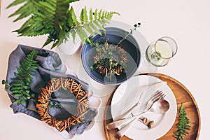 rustic table setting in natural forest style with wild ferns, wooden details and soft woodland tones.