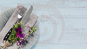 Rustic table setting with purple flowers on light wooden table