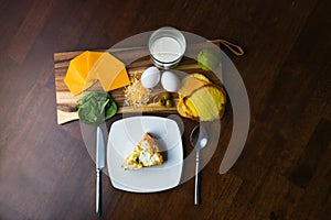 Rustic table setting with a slice of spinach and goat cheese keto pie