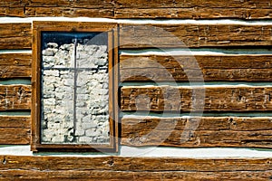 Rustic timber wall with a window barricaded by rocks
