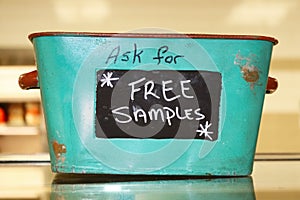 Rustic tin basket sitting on counter that says Ask for free samples photo