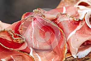 Rustic Tuscan tray with traditional italian prosciutto toscano tuscan ham. San Gimignano, Siena, Italy. Selective focus photo