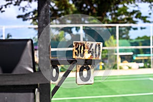 Rustic umpire chair with score counter on sunny tennis court. Simple public sport facility asset