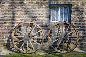 Rustic wagon wheels in front of a bricked wall