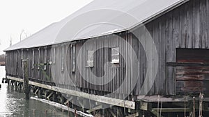 Rustic Waterside Wooden Barn on Stilts in Overcast Weather