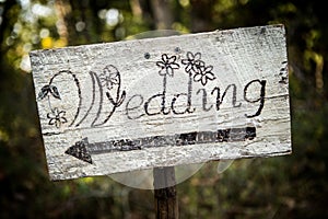 Rustic wedding arrow sign on a shovel.