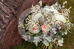 Rustic wedding bouquet with roses and succulents on green grass