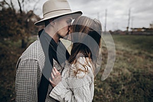 Rustic wedding concept. boho gypsy woman and man in hat kissing photo