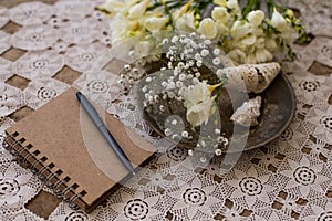 Rustic wedding planning concept. Notepad with black pen and smal