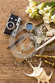 Rustic wedding planning and photography concept. Notepad, seashells and vintage camera