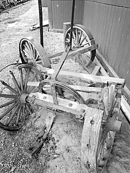 Rustic western style wagon with broken wheel, peeling paint, metal tire treads