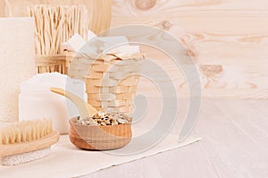 Rustic white homemade cosmetics set of natural products for body care and bath accessories in light beige wood interior.