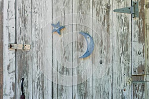 Rustic white washed door with blue moon and star