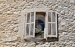 Rustic window with old wood shutters in stone rural house, Prove