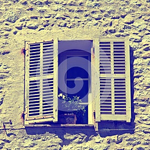 Rustic window with old wood shutters in stone rural house, Prove