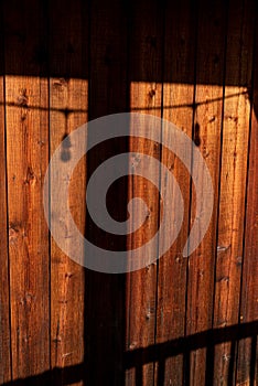 Rustic wood background with shadows of deck railing and post with string of lights