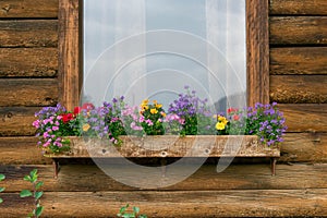 Rustic wood cabin with colorful flowers in the windowbox photo