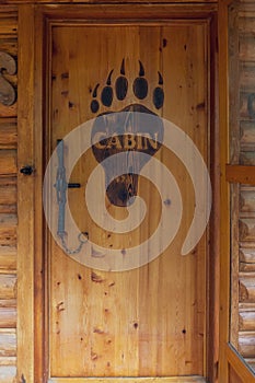 Rustic Wood Door of Log Cabin with Bear Paw Design