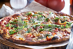 Rustic wood fired pizza with roasted garlic and arugula photo