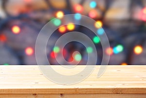 Rustic wood table in front of glitter colorfull bright bokeh lights
