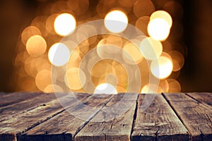 Rustic wood table in front of glitter gold bright bokeh lights