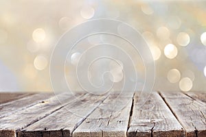 Rustic wood table in front of glitter silver and gold bright bokeh lights