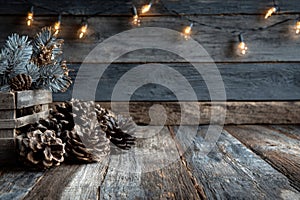 A rustic wooden background with Christmas lights and pine cones in the foreground. Generative AI.