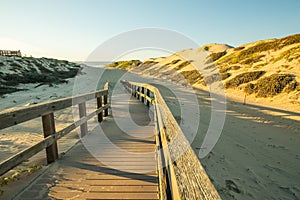 Rustic wooden beach boardwalk through sand dunes, Oso Flaco Lake, CA