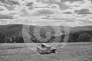 Rustic wooden bench, table and beautiful nature with meadow and hills