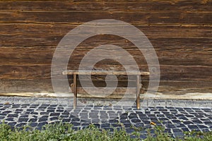 Rustic wooden bench and wall outside of rural yard background and stone paved floor