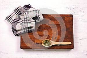 Rustic wooden board, checkered napkin and lentils seeds with cop