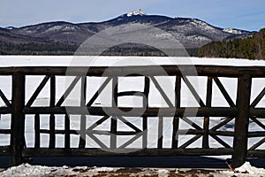 A rustic wooden bridge crosses an icy stream