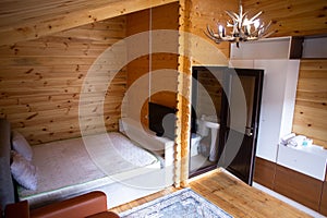 Rustic wooden cabin interior with bed, sofa, and armoire