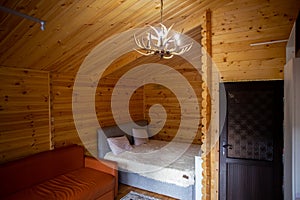 Rustic wooden cabin interior with bed, sofa, and armoire photo
