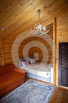 Rustic wooden cabin interior with bed, sofa, and armoire photo