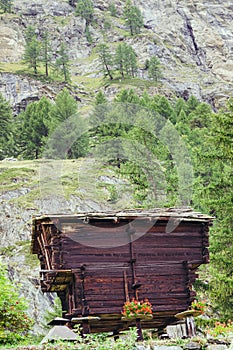 A rustic wooden cabin nestled in the rugged terrain of the Swiss Alps