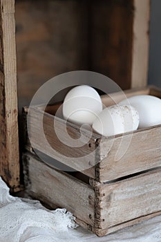 Rustic wooden crate with white eggs.