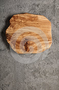 Rustic wooden cutting board on grey cement surface top view